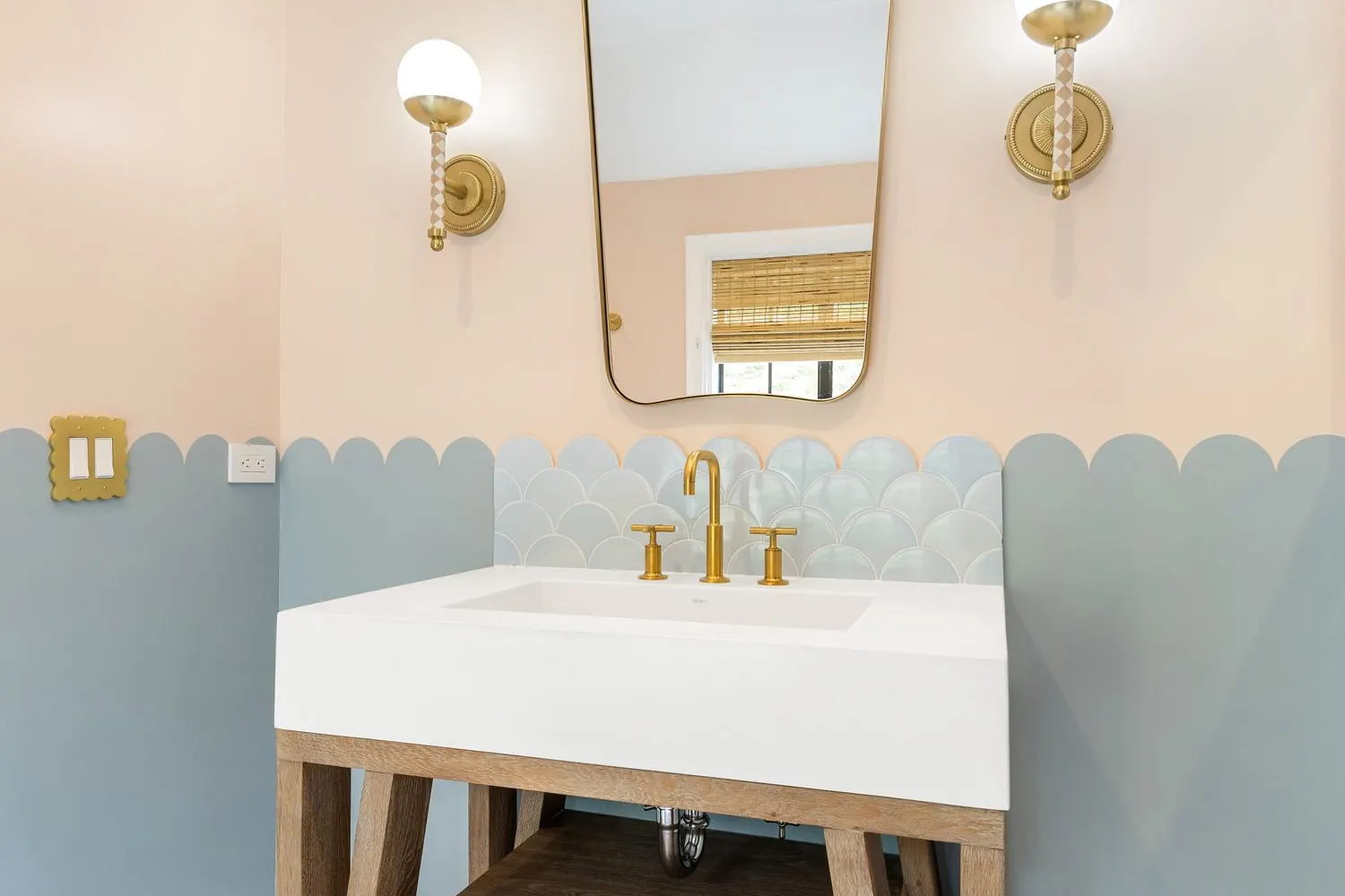 Fish-scale wall tile and brass vanity fixtures